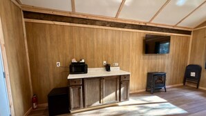 A compact kitchen with wooden cabinets, a countertop, and a stove.