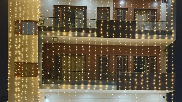 A multi-story building with balconies and string lights. - BJ Villa (Mohali)