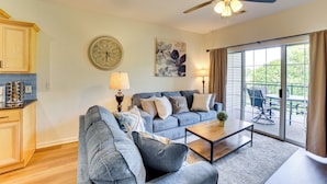 A living room with a sofa, coffee table, and a dining area with chairs and a table. - Game & Movie Rooms! Unit 4 Mi to Branson Landing (Branson)