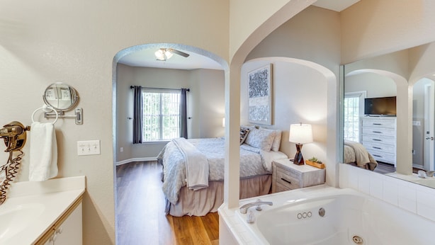 A modern bathroom with a large bathtub, a vanity with a mirror, and a shower area. - Game & Movie Rooms! Unit 4 Mi to Branson Landing (Branson)
