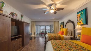 A hotel room with a bed, a TV, a ceiling fan, a desk, and a window with a view. - 2-bedroom resort in fabulous B.C.S. with WiFi, AC, fitness room (B.C.S.)
