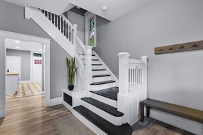Un escalier avec des balustrades blanches et des marches sombres menant à un palier.