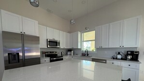 Una cocina moderna con armarios blancos, electrodomésticos de acero inoxidable y una isla grande.