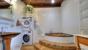 A compact laundry room with a washing machine, a sink, and a bathtub. - Ain Amour de Bresse - DOMSURE (DOMSURE)