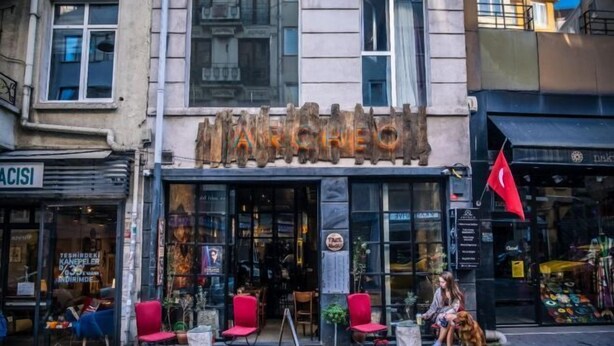 A storefront with a sign reading "MARCHEO" and a red flag hanging outside. - Archeo Cafe and Hostel (Istanbul)