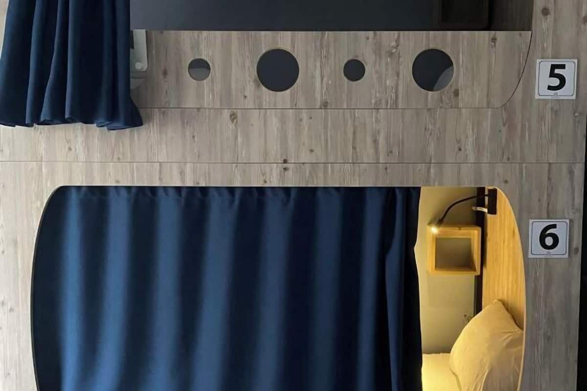 A room with a wooden wall, numbered 5 and 6, a curtain, and a small wooden shelf.