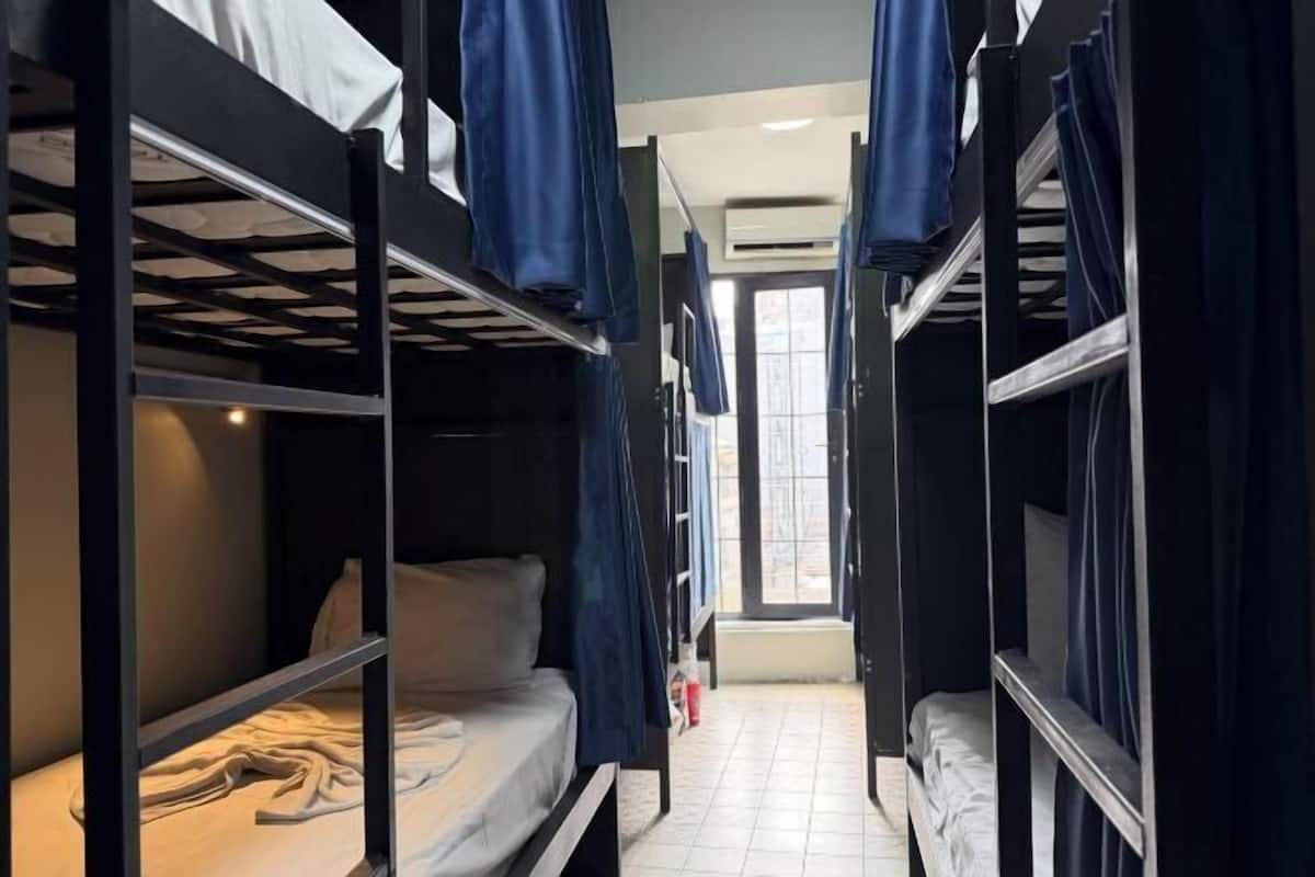 A bunk bed room with curtains, a window, and a tiled floor.
