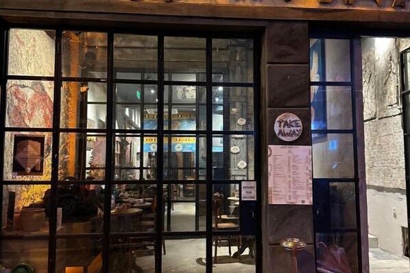A restaurant with a rustic interior, visible through a glass door with a 'Take Away' sign. - Archeo Cafe and Hostel (Istanbul)
