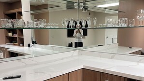 Une cuisine moderne dotée d’un grand miroir, de meubles en bois et d’un meuble à vin.
