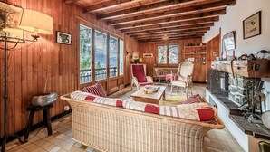 A wooden interior with a sofa, chairs, a fireplace, and a bookshelf. - Chalet 'Franclair' with Mountain View, Shared Garden and Wi-Fi (Samoëns)