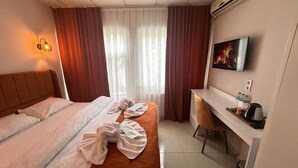 A hotel room with a bed, a desk, a television, and a window with curtains. - Kadıköy Bull Hotel (Istanbul)