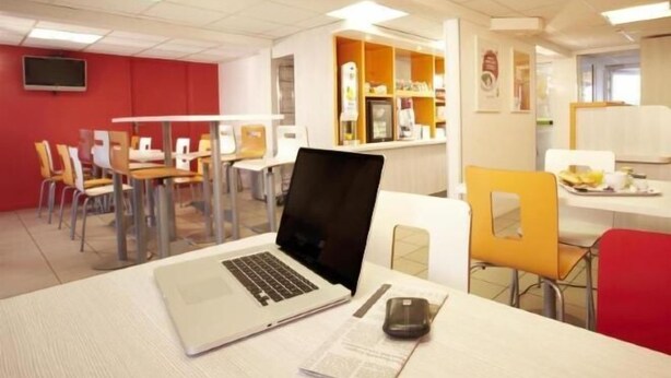 Ein moderner Arbeitsraum mit Schreibtischen, Stühlen und einem Laptop.