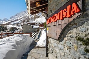 A snow-covered path leading to a building with a sign reading 'ARTHEMISIA.'