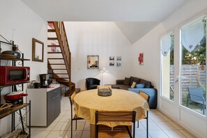 A compact living space with a kitchen, dining area, and a staircase leading to an upper level. - Maison Montagnac – Peaceful Retreat with Garden in the Heart of the Lot (gignac)