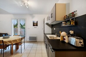 A modern kitchen with a dining area, featuring a built-in stove, a sink, and a variety of kitchen utensils.