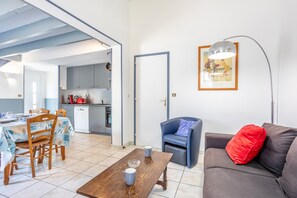 Uma sala de estar com sofá, mesa de centro e área de jantar com cadeiras e mesa.