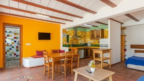 Un espace de vie compact comprenant un coin repas, une kitchenette et un lit.