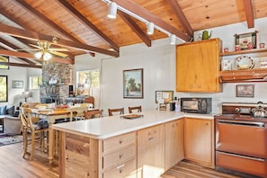 Una cocina amplia con armarios de madera, una isla central, un microondas y una estufa.