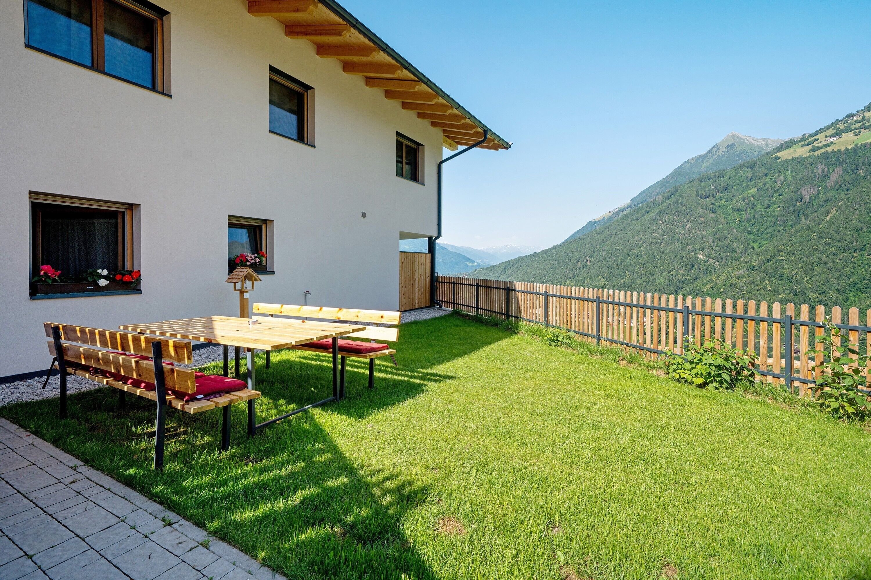 A house with a patio, a wooden fence, and a mountain view.