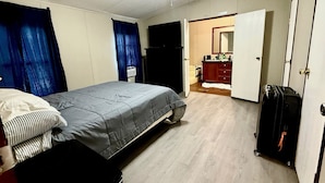 A bedroom with a bed, a wardrobe, and a suitcase. - Venice fishing/hunting lodging (Boothville-venice)