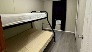 A small, single-room accommodation with a bunk bed, a toilet, and a door. - Venice fishing/hunting lodging (Boothville-venice)