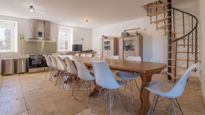 A modern kitchen with a dining area, stainless steel appliances, and a spiral staircase. - Holiday Home 'Mas Des Genêts' with Mountain View, Balcony and Wi-Fi (Laurac-en-Vivarais)