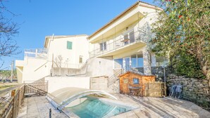 A two-story building with a swimming pool, outdoor seating, and a stone wall. - Holiday Home 'Très Belle Maison' with Mountain View, Balcony and Wi-Fi (Laurac-en-Vivarais)