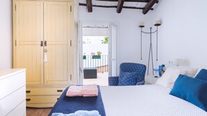 Une chambre avec un lit, une armoire, une chaise et une vue sur le balcon.