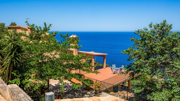 A coastal property with a terrace overlooking the sea, a staircase, and lush greenery. - Villa with wi-fi and stunning sea views. (Banyalbufar)