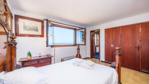 A hotel room with a bed, a dresser, a mirror, a wardrobe, and a window. - Villa with wi-fi and stunning sea views. (Banyalbufar)
