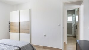 A bedroom with a bed, a wardrobe, and a dresser.