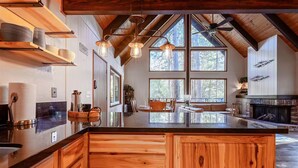 Una cocina amplia con una isla grande, armarios de madera y una chimenea.
