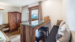 Un espacio habitable compacto con una mesa de vidrio, un mueble de madera y un sofá con cojines.
