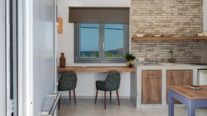 Eine moderne Küche mit Ziegelrückwand, einem Fenster mit Blick und zwei Stühlen.