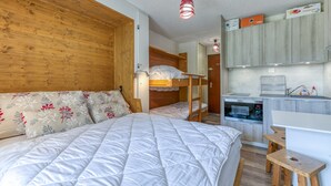 A bedroom with a bunk bed, a desk, and a kitchenette. - Well-Equipped Studio with Enclosed Balcony and Mountain View (La Morte)