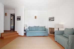 Una sala de estar con un sofá, una lámpara y una chimenea.