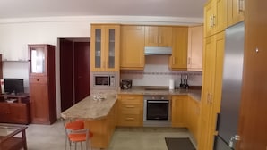 A kitchen with wooden cabinets, a microwave, an oven, and a refrigerator. - Dacil - Relaxing Getaway near Beach, La Restinga (Las Puntas)