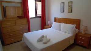 A neatly made bed with white linens, a wooden headboard, and two bedside tables with lamps. - Dacil - Relaxing Getaway near Beach, La Restinga (Las Puntas)