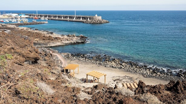 A coastal area with a rocky beach, a pier with boats, and a lighthouse. - Dacil - Relaxing Getaway near Beach, La Restinga (Las Puntas)