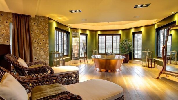 A room with a large bathtub, wicker furniture, and green walls. - Cbh Ramside Hotel Golf Spa Durham (Durham)