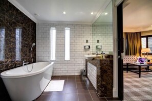 Un bagno moderno con una vasca da bagno freestanding, un mobile lavabo con specchio e una cabina doccia.
