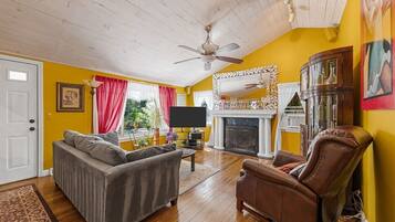 A living room with a sofa, armchair, and a fireplace.