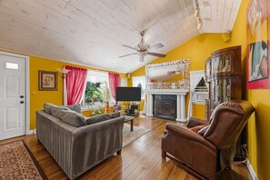 A living room with a sofa, armchair, and a fireplace.