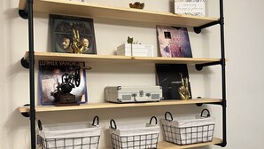 Eine wandmontierte Regalkonstruktion mit verschiedenen Dekorationsobjekten und Aufbewahrungskörben.