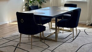 Ein Essbereich mit einem Tisch, Stühlen und einer Chandelüster.