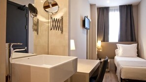 Camera d'albergo con vasca da bagno ampia, una scrivania, un letto e una TV.