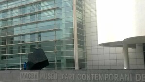 En modern byggnad med en glasfasad och en skylt med texten ”MAGBA MUSEU D’ART CONTEMPORANI DE”.