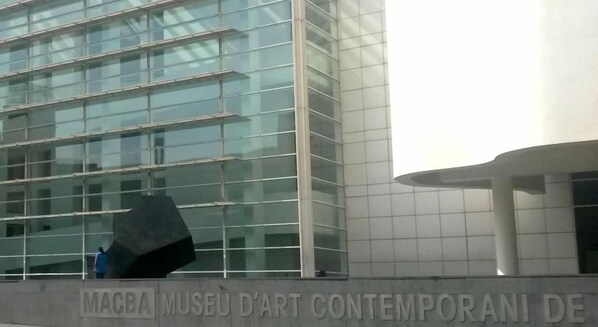 A modern building with a glass facade and a sign reading "MAGBA MUSEU D'ART CONTEMPORANI DE". - May Ramblas Hotel (Barcelona)