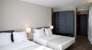 A hotel room with two beds, a wardrobe, and a bathroom. - May Ramblas Hotel (Barcelona)