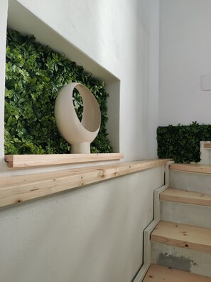 A staircase with wooden steps and a wall-mounted planter with green foliage.
